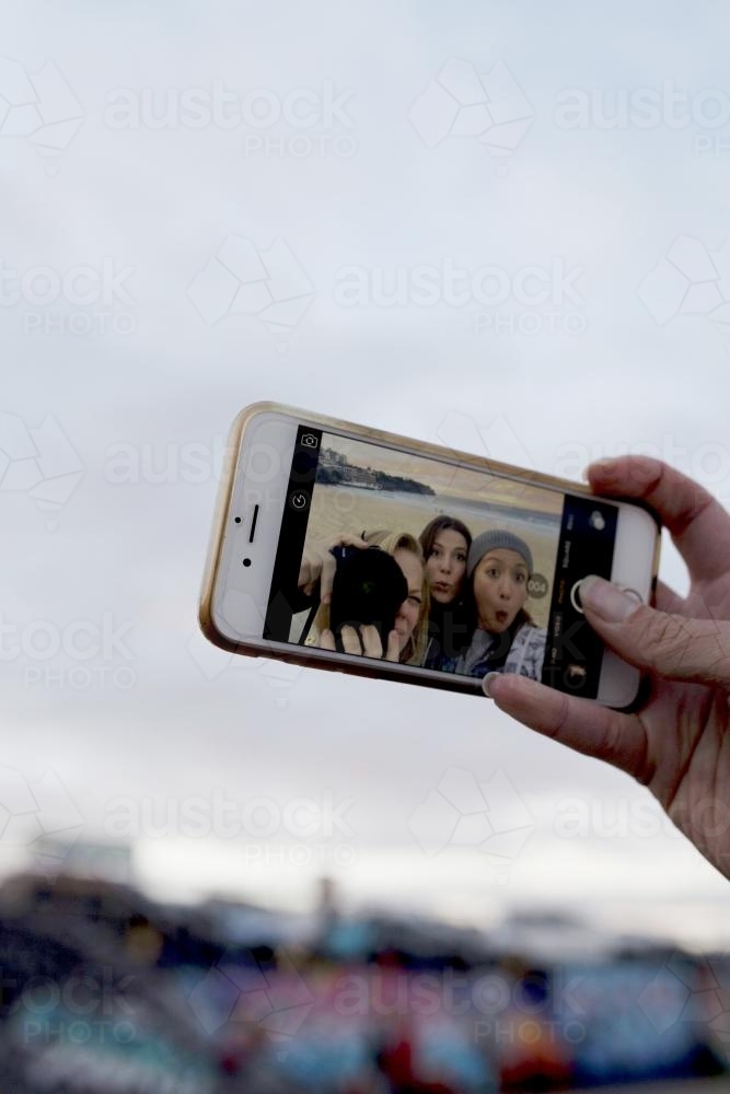 Three girls taking a selfie on their iphone - Australian Stock Image