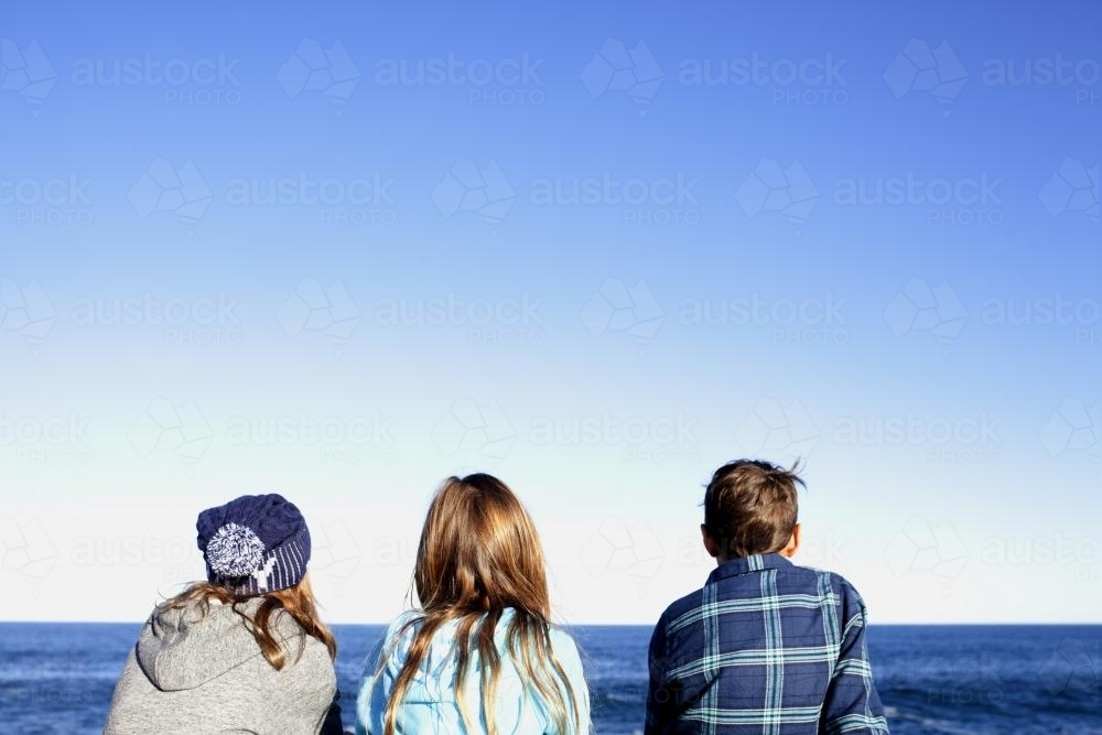 Three kids looking out at the ocean - Australian Stock Image