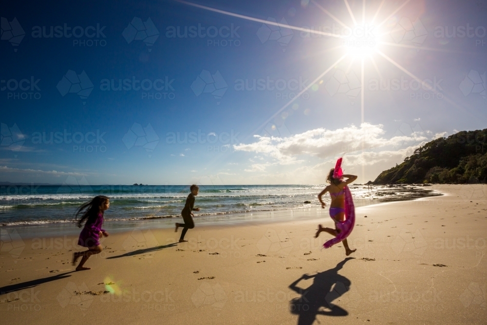 Three kids running along Watego's Beach - Australian Stock Image