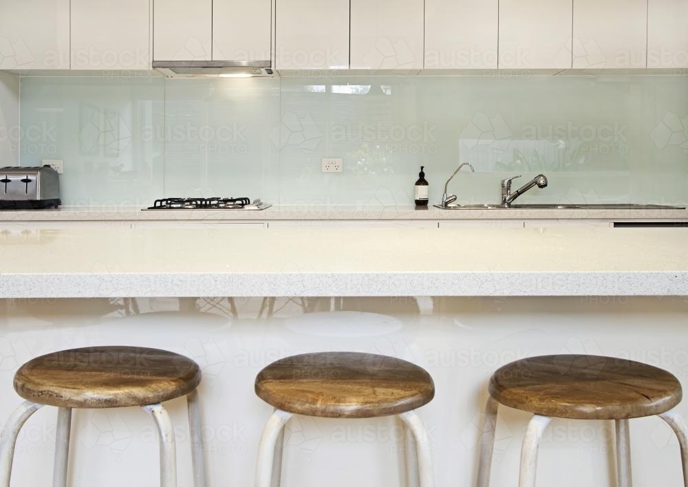 Three kitchen island stools in modern townhouse - Australian Stock Image