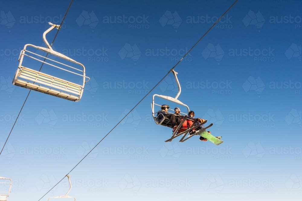 three men on ski lift - Australian Stock Image