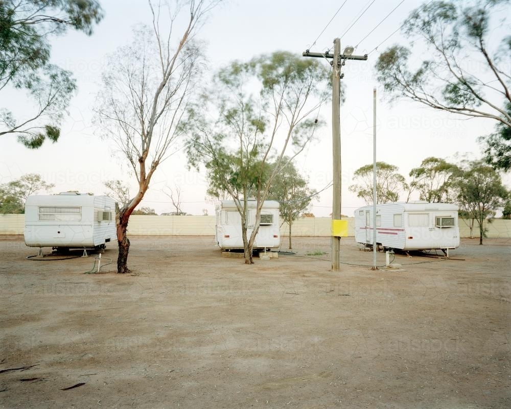 Three old caravans parked in dusty, remote caravan park - Australian Stock Image