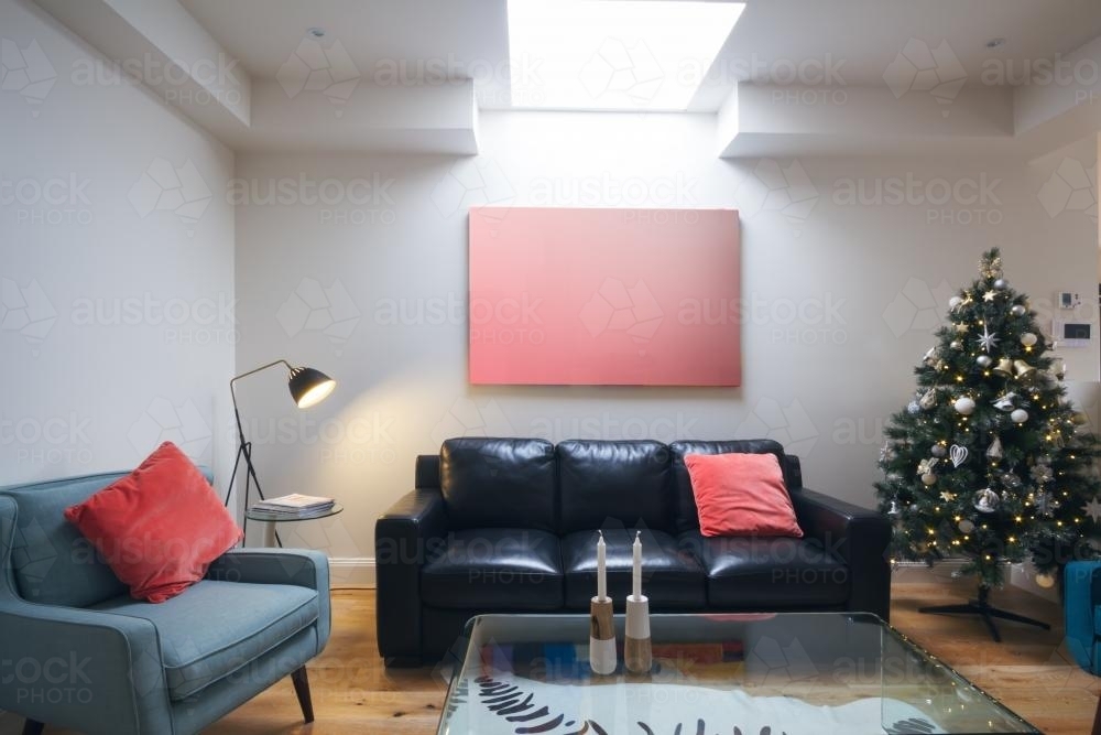 Three seater sofa in living room with christmas tree and blank artwork - Australian Stock Image