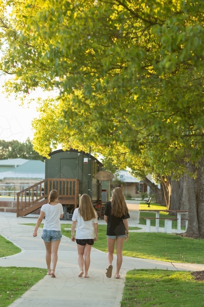 Three teenage friends walking on a concrete path - Australian Stock Image