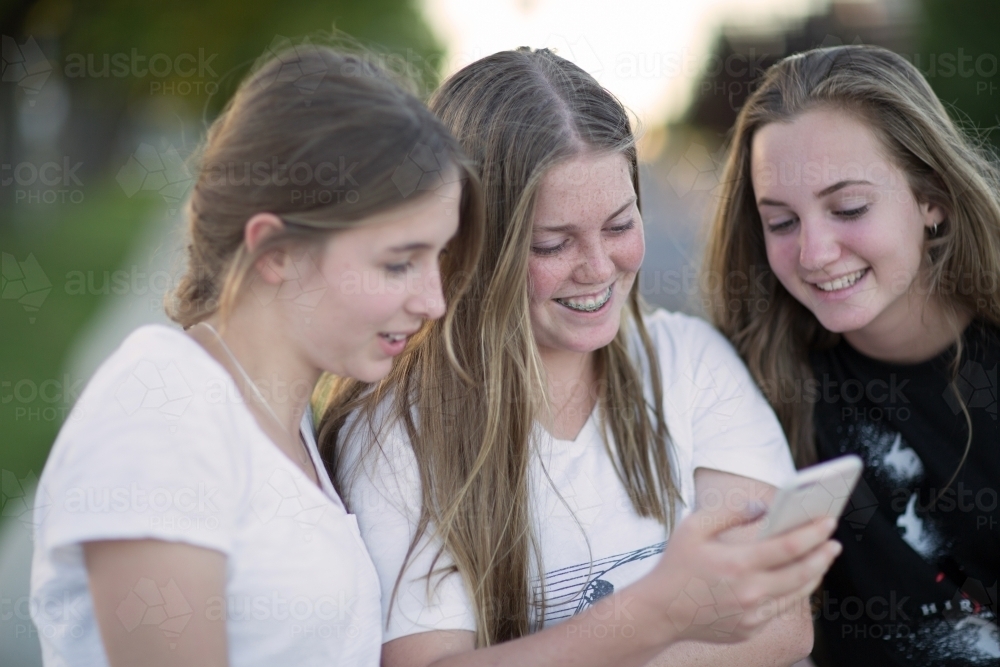 Three teenage girls looking at smartphone - Australian Stock Image