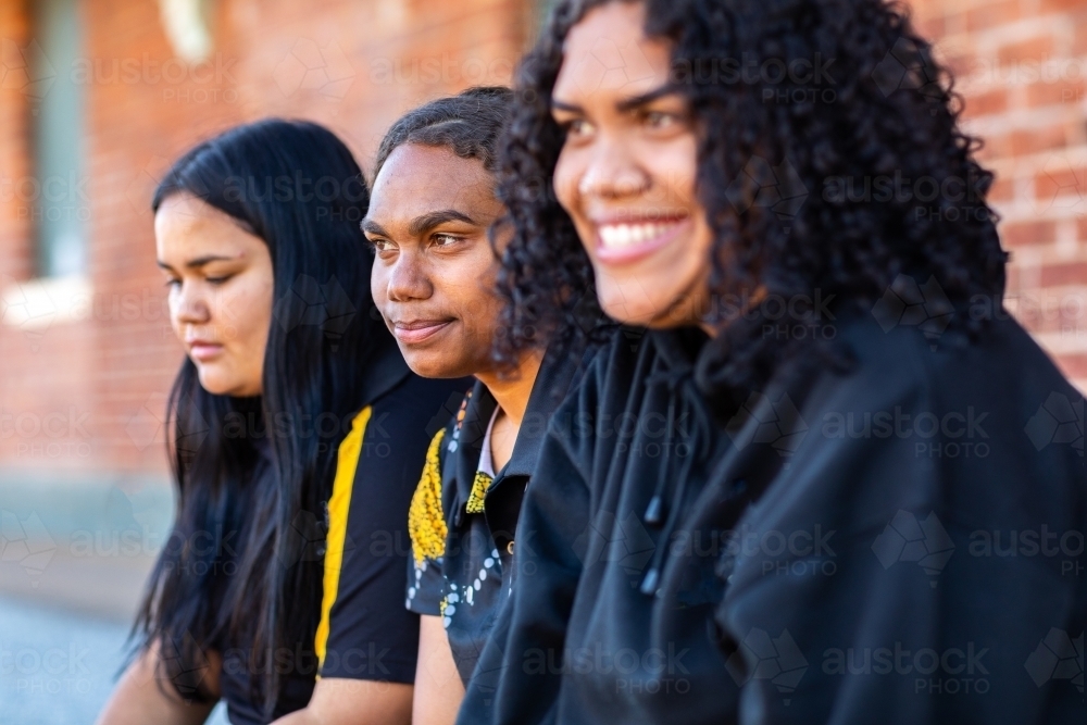three teenage girls sitting together - Australian Stock Image