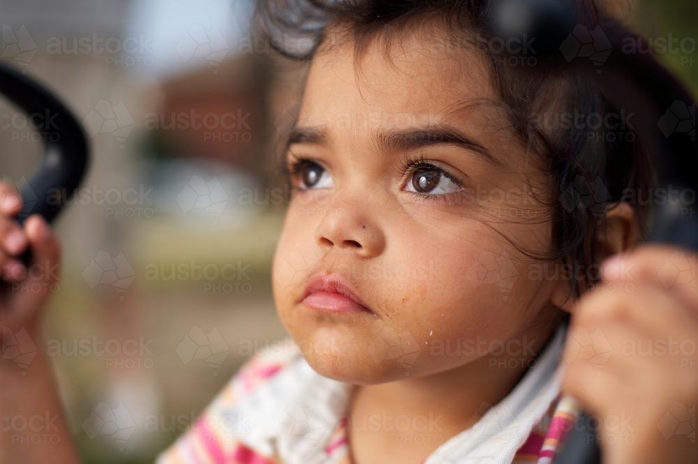 Three Year Old Aboriginal Girl Holding Pusher Handles - Australian Stock Image
