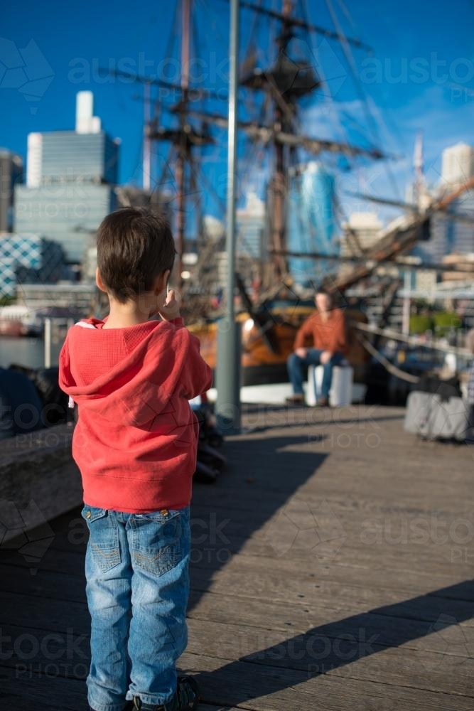 Three year old boy takes photos around Darling Harbour - Australian Stock Image