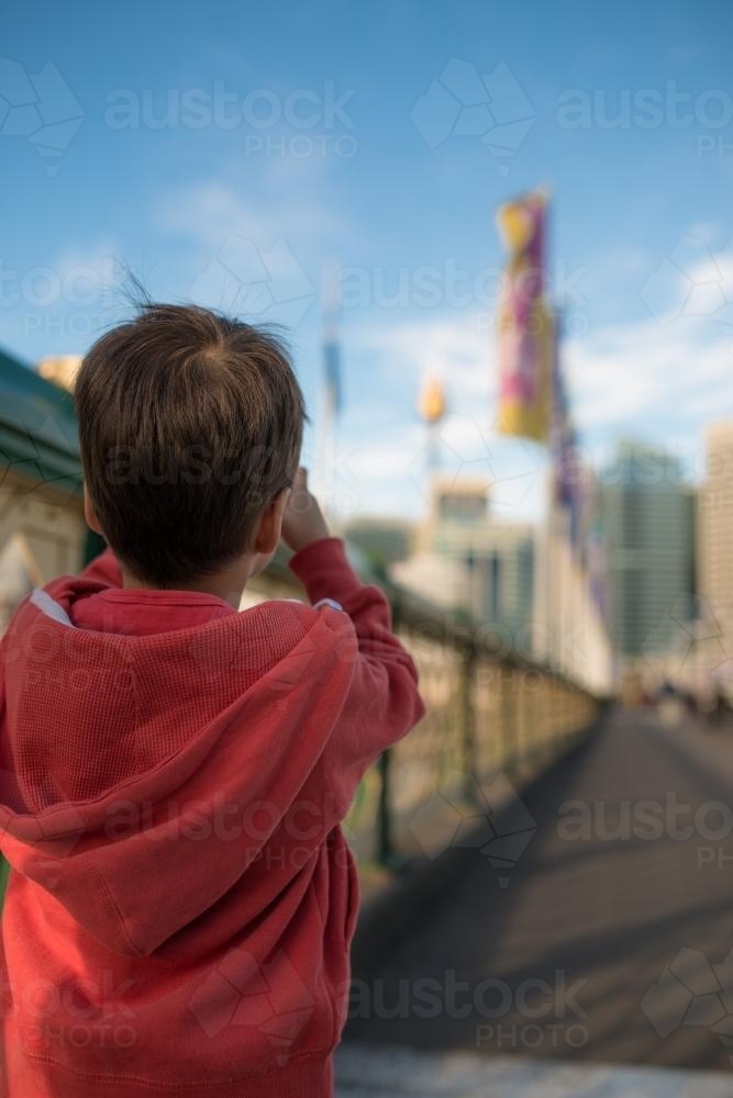 Three year old boy takes photos around Darling Harbour - Australian Stock Image