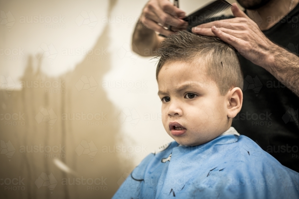 Three year old mixed race boy having a haircut - Australian Stock Image