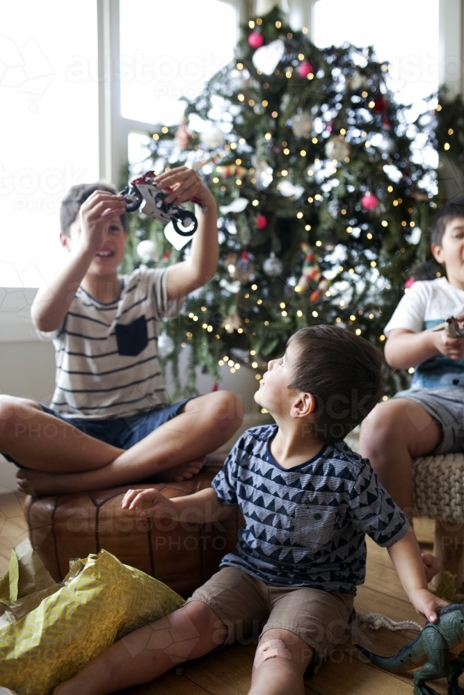 Three young boys opening christmas presents - Australian Stock Image