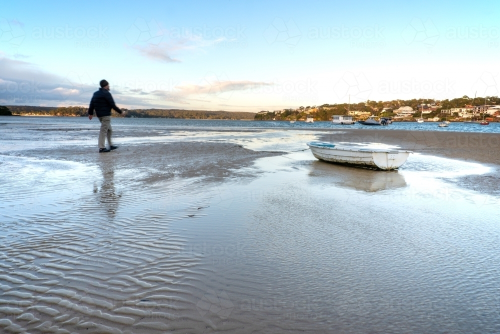 Tidal flats with small stranded boat at Gunnamatta Bay - Australian Stock Image