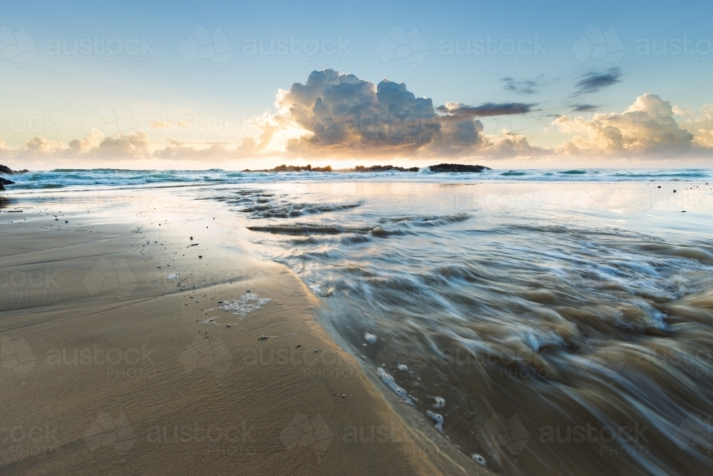 Tide going out to sea at sunrise - Australian Stock Image