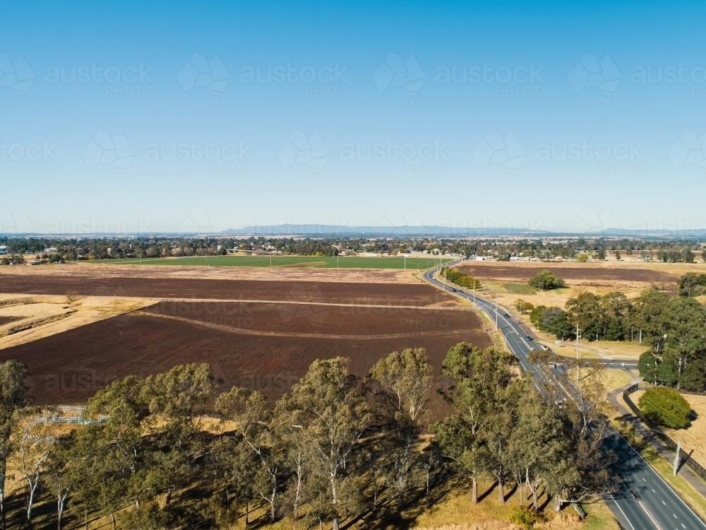 Tilled brown farm paddocks on floodplain flats in Singleton, NSW - Australian Stock Image
