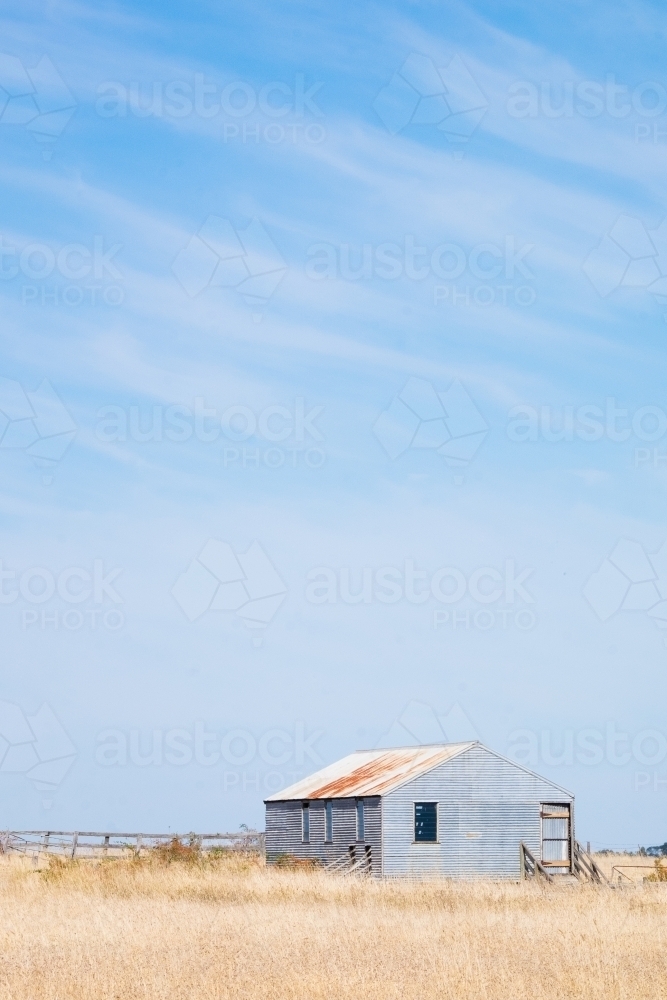 Tin farm shed sits in the country landscape - Australian Stock Image