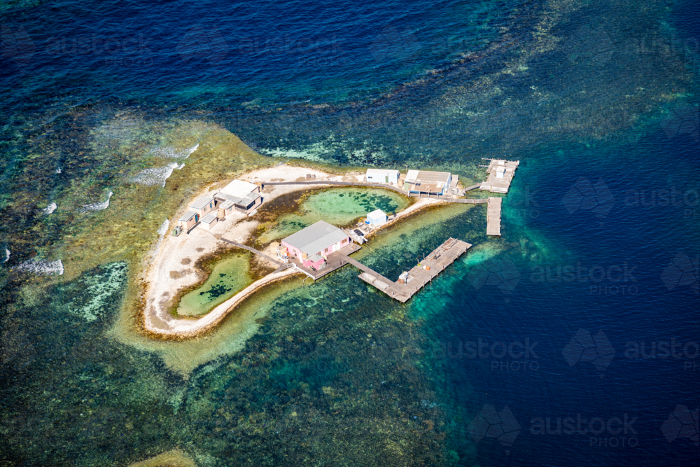 Tiny reef outpost surrounded by deep blue water. - Australian Stock Image