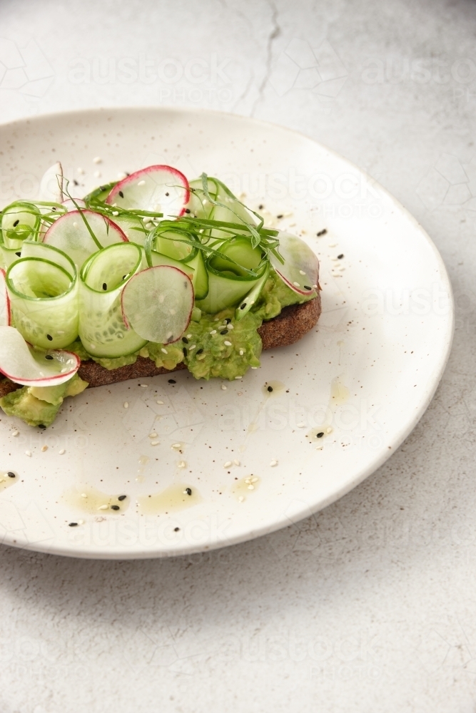 Toast with thin sliced cucumbers and scallions on top - Australian Stock Image