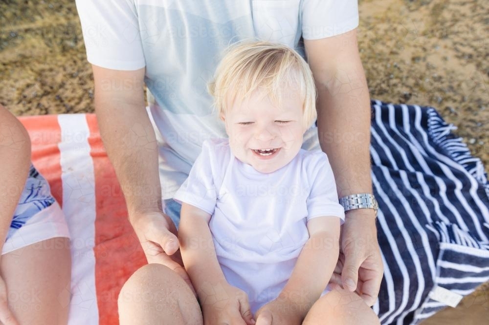 Toddler boy laughing as dad tickles him - Australian Stock Image