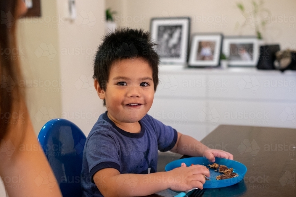 Toddler enjoying his afternoon snack with mum - Australian Stock Image