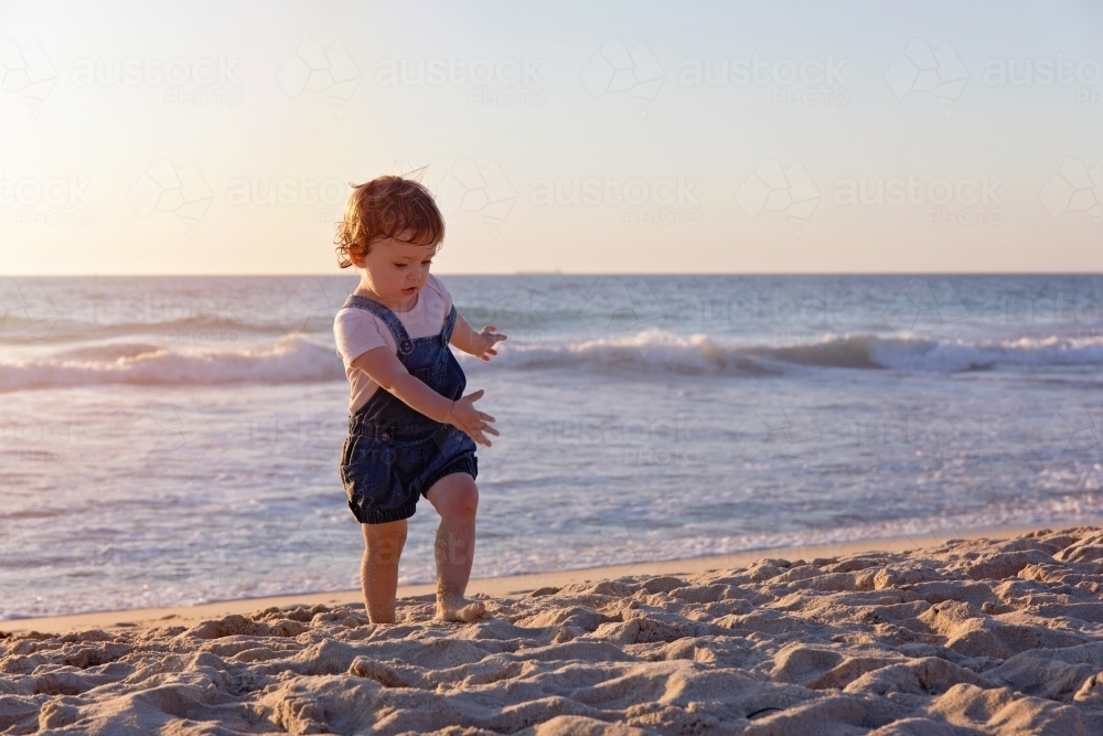 Toddler Girl Running On The Beach At Sunset - Australian Stock Image