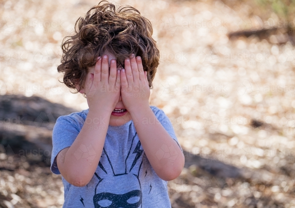 Image of Toddler plays hide and seek game - Austockphoto