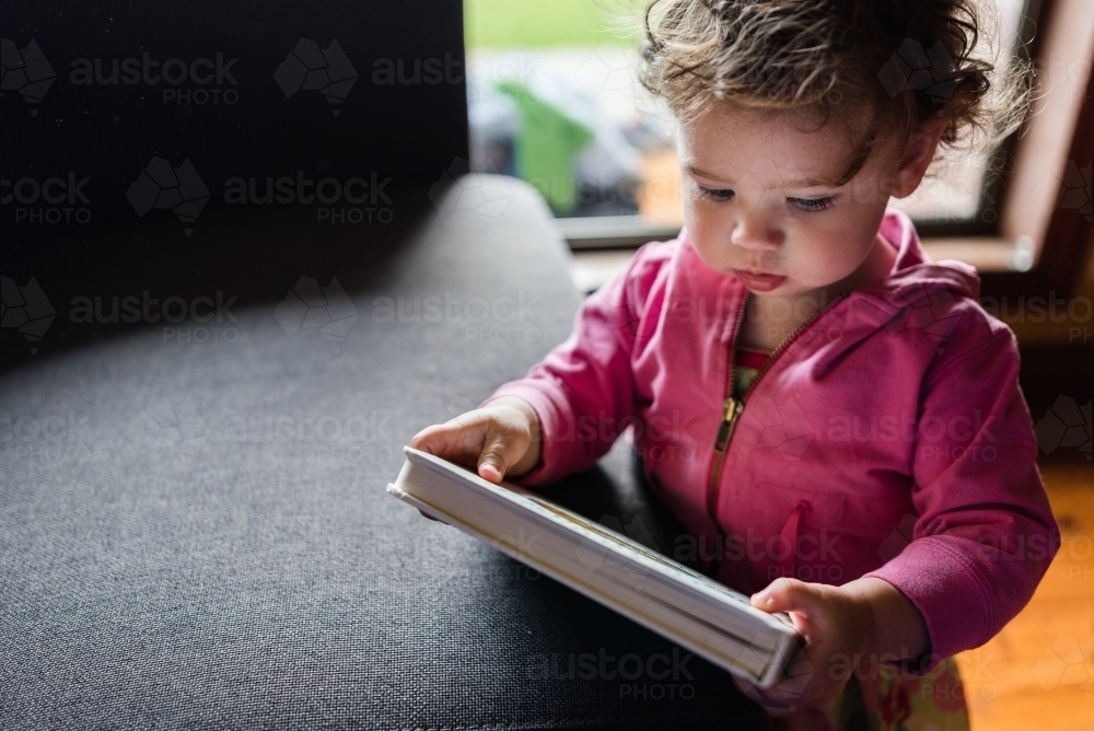 Toddler reading book - Australian Stock Image