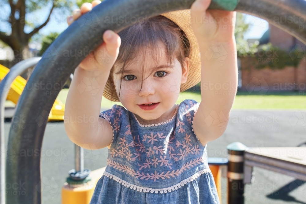 Toddler wearing hat in park playground - Australian Stock Image