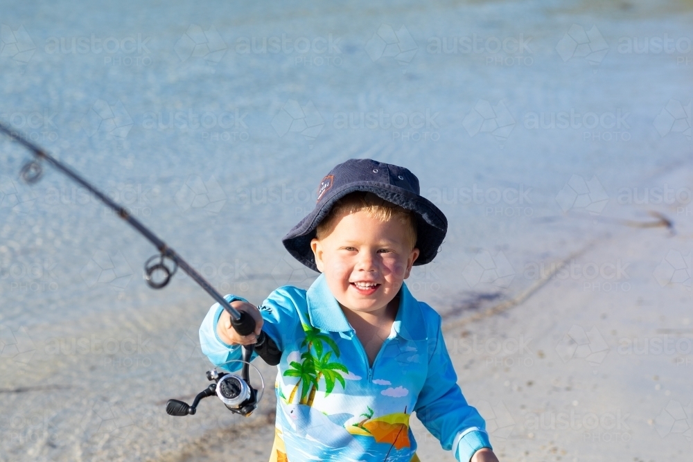toddler with fishing rod at the waters edge - Australian Stock Image