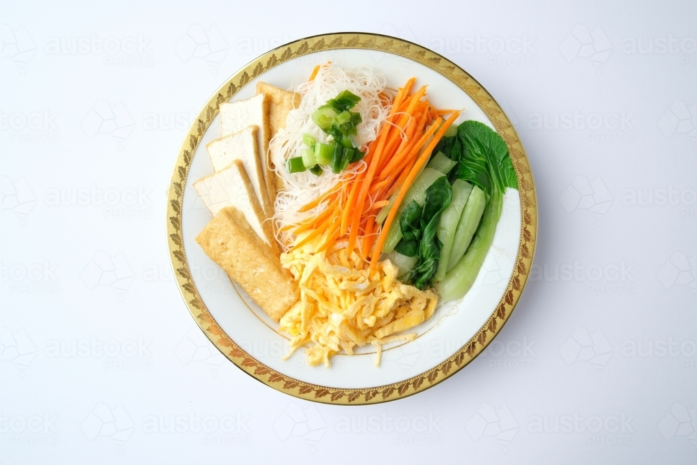 Image of Tofu and egg noodle salad served in a bowl with a gold rim