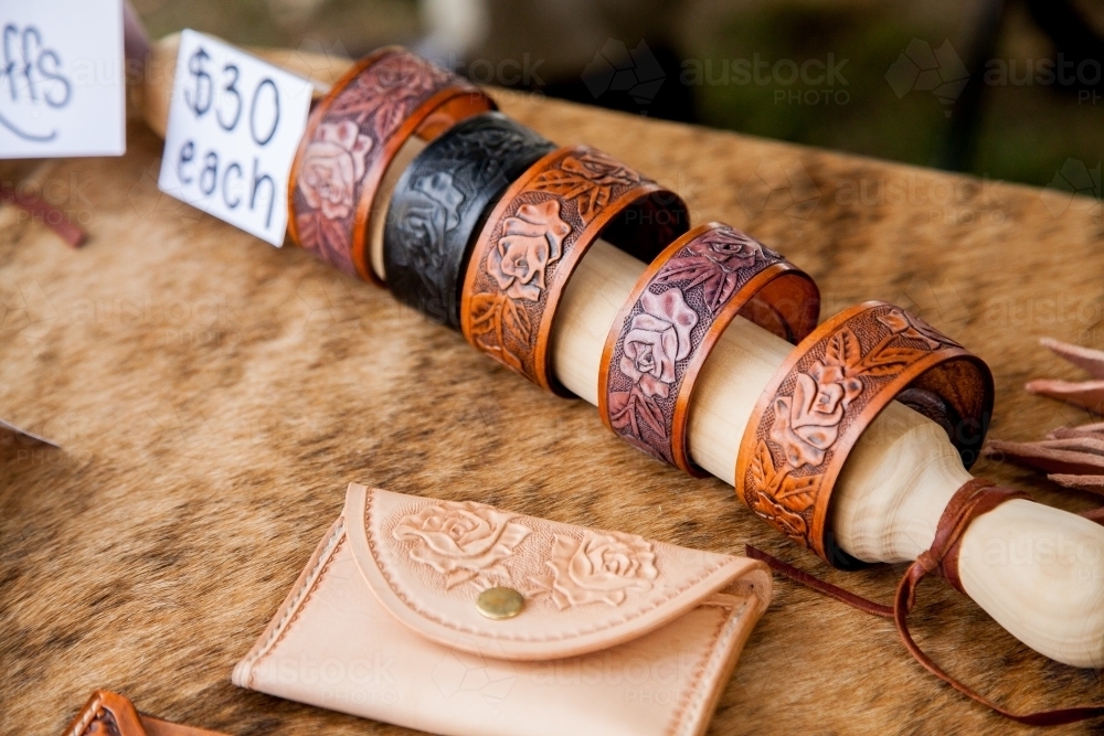 Tooled leather wallets and cuffs on display at a market - Australian Stock Image