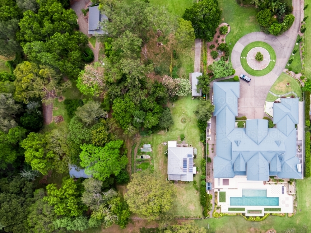Top down aerial view of luxury homes beside small original house - Australian Stock Image
