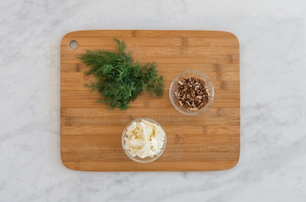 Top down of dill and walnut ingredients on chopping board - Australian Stock Image