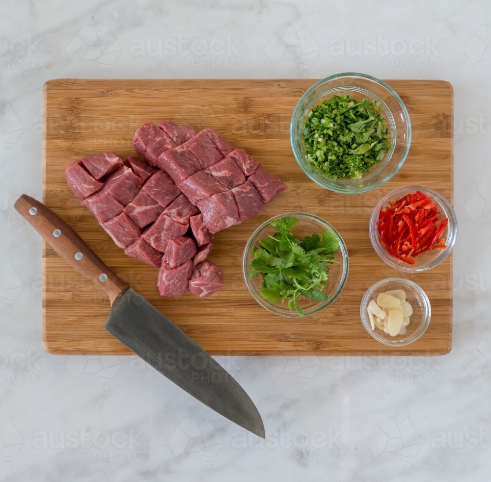 Top down of meat and vegetable ingredients on chopping board - Australian Stock Image