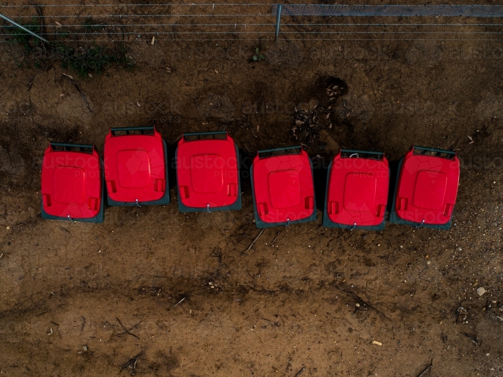 Top down of red garbage bins in a line - Australian Stock Image