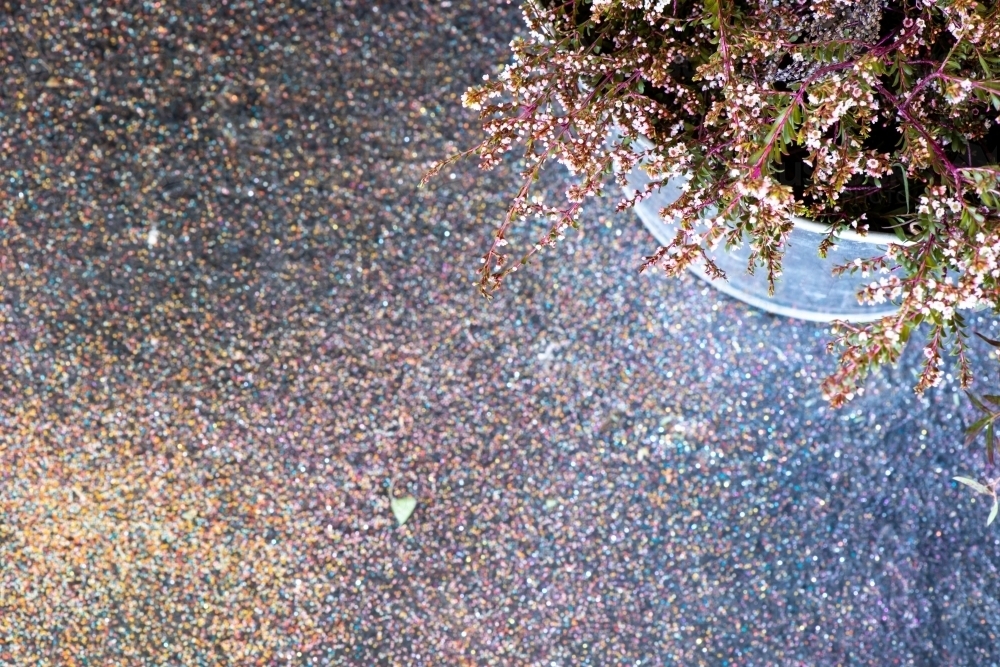 Top down partial view of  small flowers in a metal bucket and a glitter covered floor - Australian Stock Image
