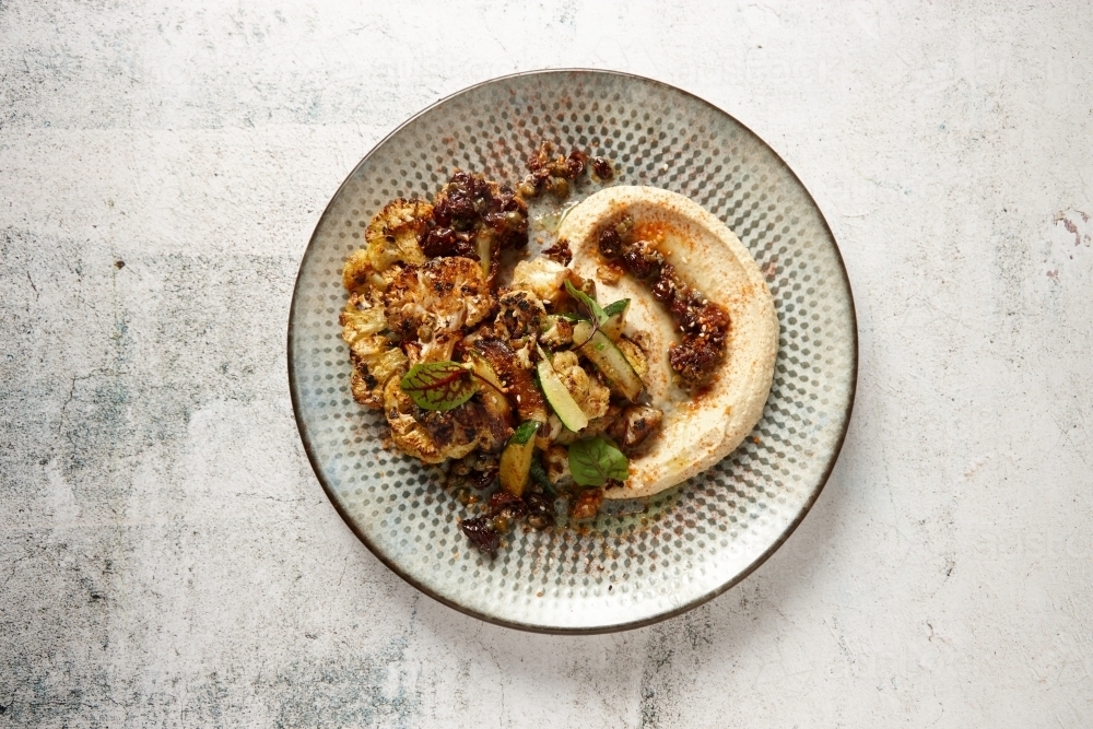 Top down view of a plate of Mediterranean food - vegetables with hummus - Australian Stock Image