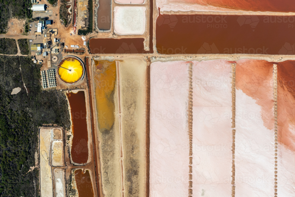 Top-down view of industrial salt pans with pink, orange, and yellow mineral pools. - Australian Stock Image