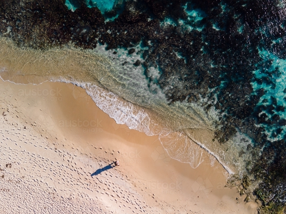 Top down view of lone person walking along sand on North Beach, WA - Australian Stock Image