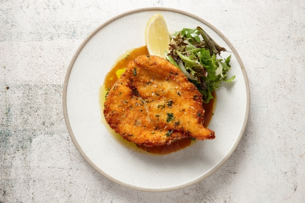 Top down view of plate of chicken schnitzel on mash - Australian Stock Image