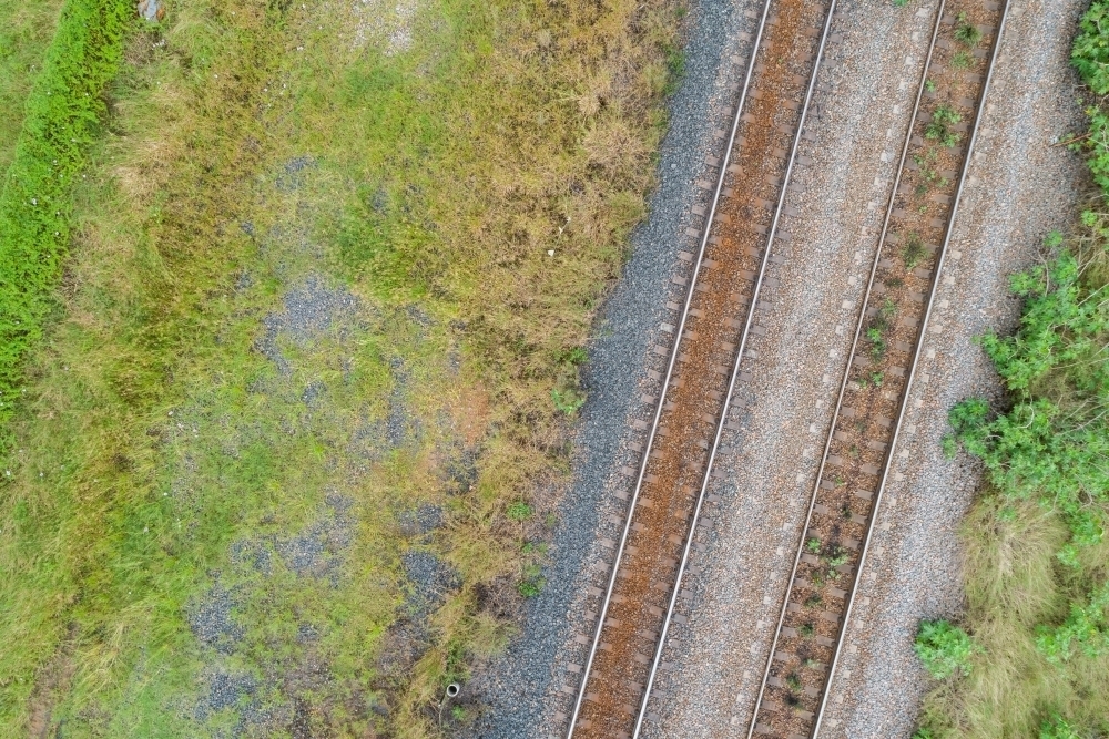 Top down view of railway line and grass beside train track - Australian Stock Image