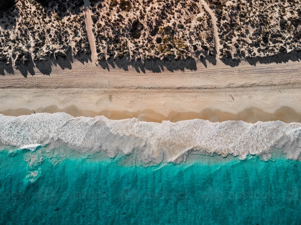 top shot of  sea waves, white sand shores, bushes and trees on a sunny day - Australian Stock Image