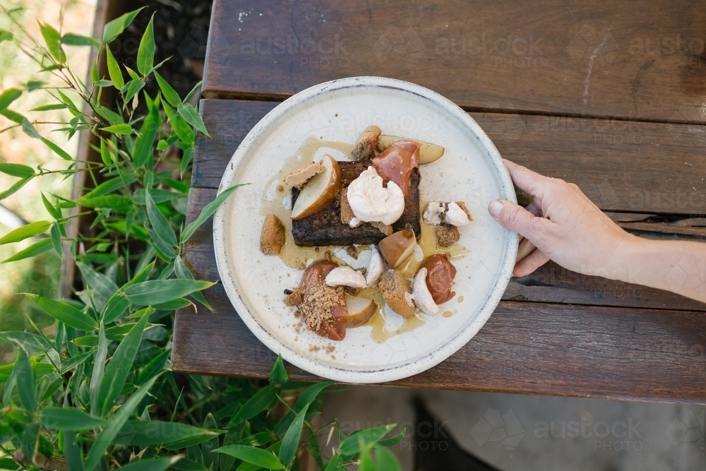 Top view of a dessert on a round plate served on a wooden table - Australian Stock Image