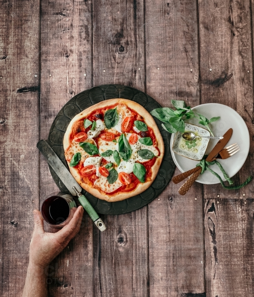 Top view of a whole pizza and a glass of wine - Australian Stock Image