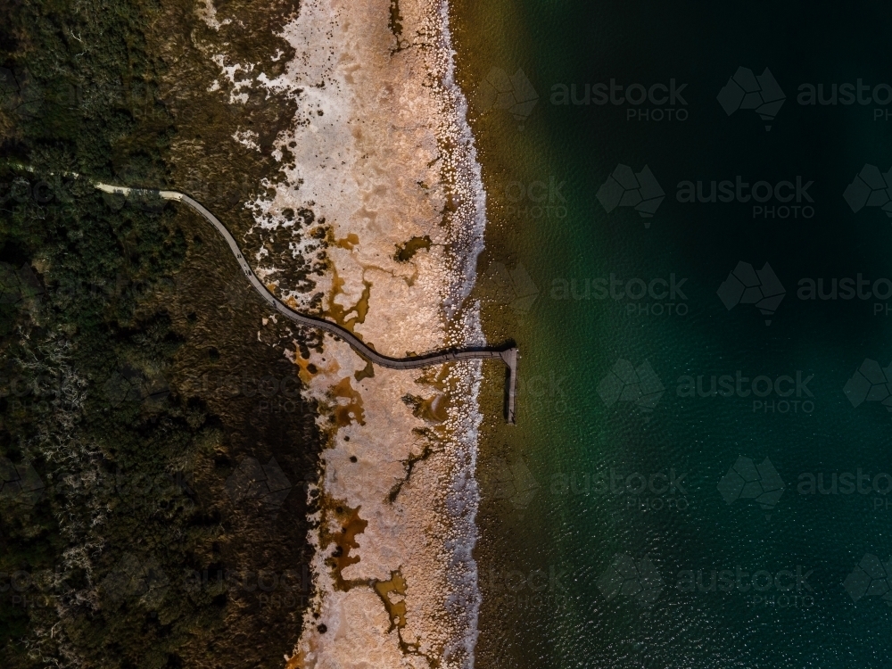 top view shot of a beach walkway with bushes and trees on a sunny day - Australian Stock Image