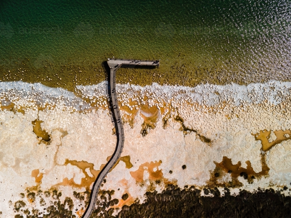top view shot of a beach walkway with bushes, trees and waves on a sunny day - Australian Stock Image