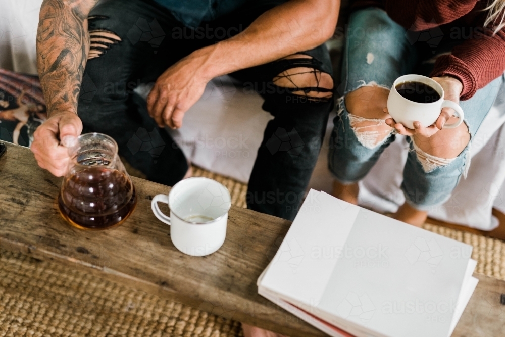 Top view shot of a man and a woman sitting about to drink their coffee - Australian Stock Image