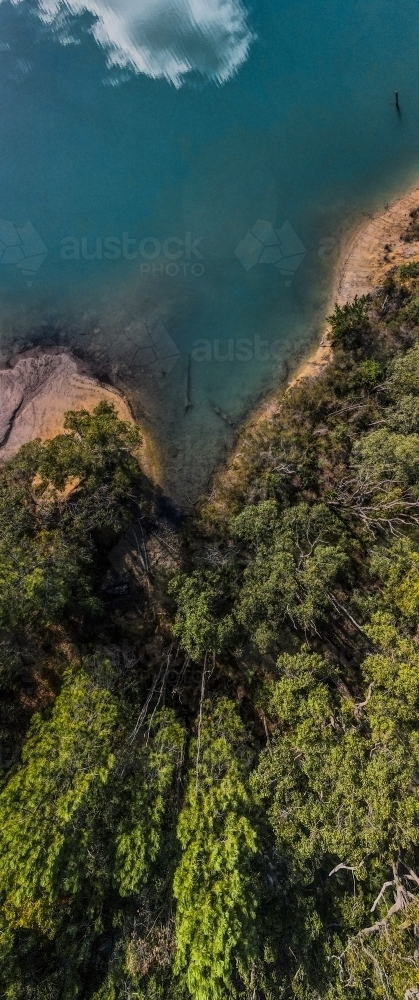 top view shot of blue lake water with bush hills and green trees - Australian Stock Image