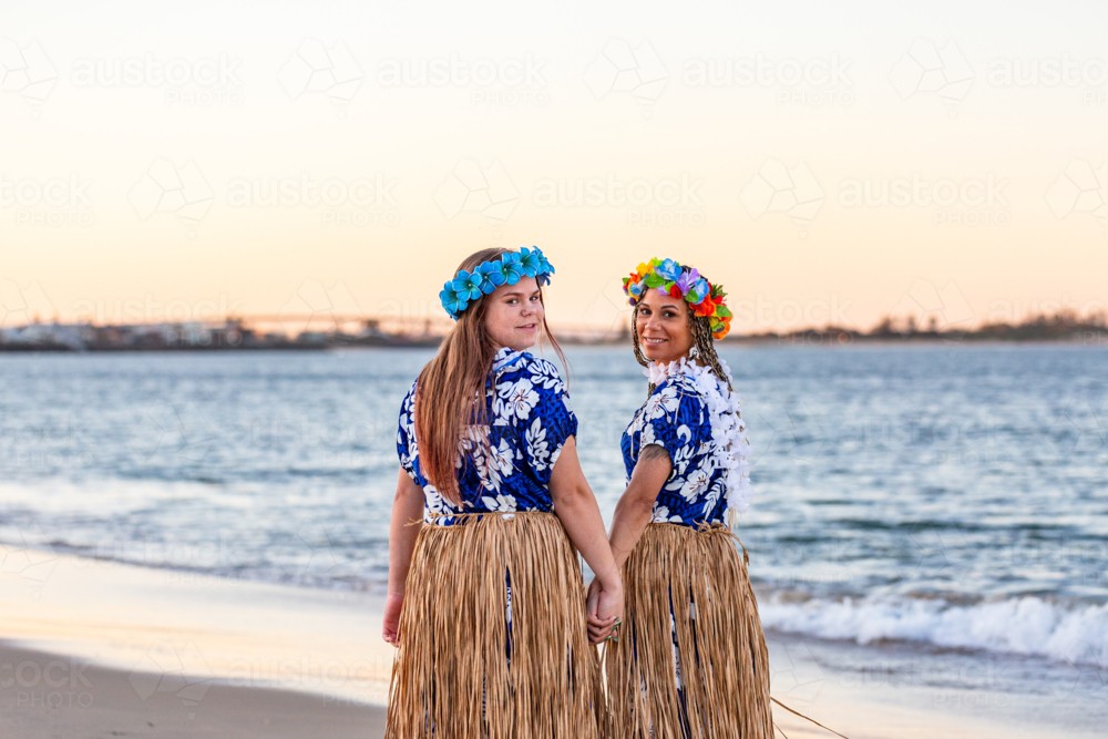 Torres Straight Islander mum with teenaged daughter by the ocean at dusk - Australian Stock Image