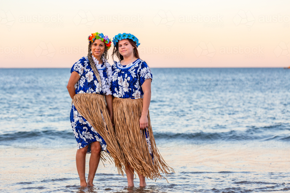 Torres Straight Islander mum with teenaged daughter standing by the ocean at dusk - Australian Stock Image