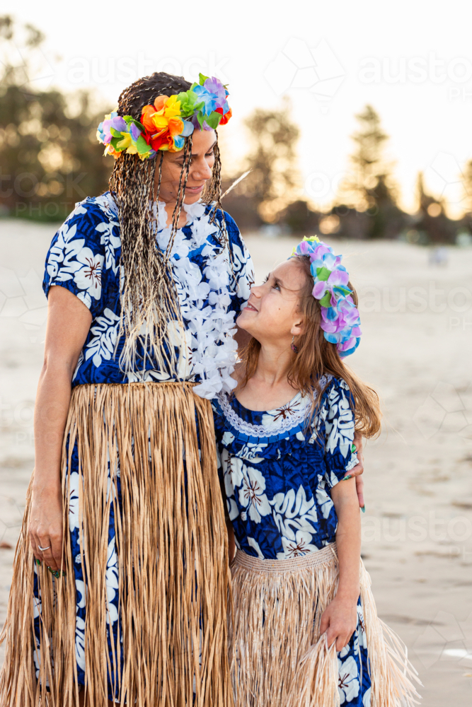 Torres Strait Islander girl looking up at mother in traditional dancer floral garland - Australian Stock Image